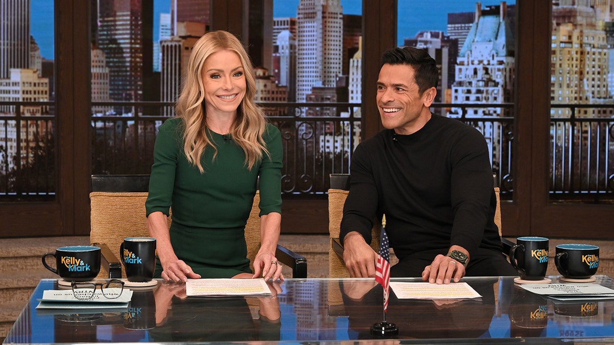 Kelly Ripa and Mark Consuelos wearing green and black on the "Live with Kelly and Mark" show.