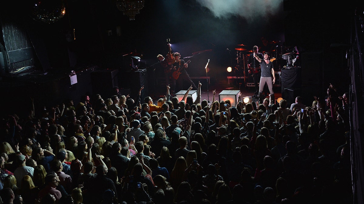 Thomas Rhett performing in front of a large audience in NYC in 2014