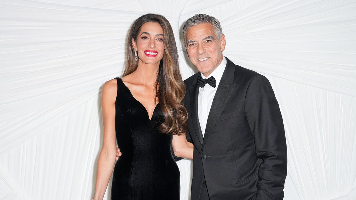 Amal Clooney and George Clooney posing together at The Albies, hosted by the Clooney Foundation for Justice.