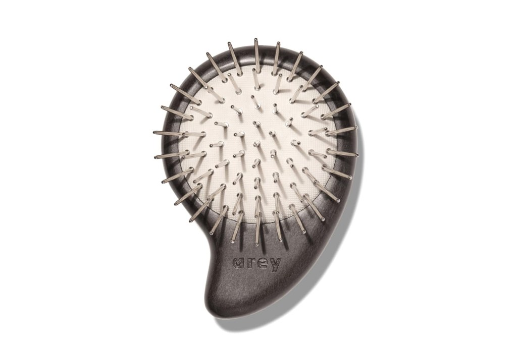 Grey-handled Arey hairbrush with metal bristles.