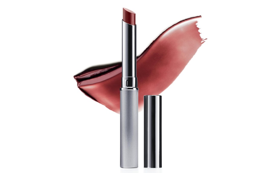 A red lipstick in a silver tube with a cap, next to a swatch of the same lipstick color.