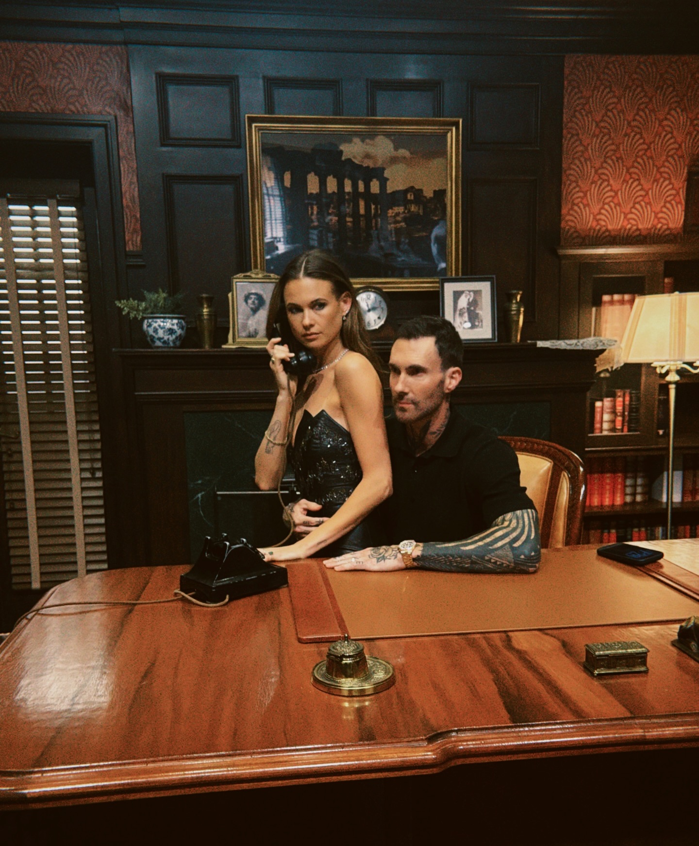 Behati Prinsloo and  hubby Adam Levine sit at Vito Corleone’s desk at the Academy Museum of Motion Pictures in LA.