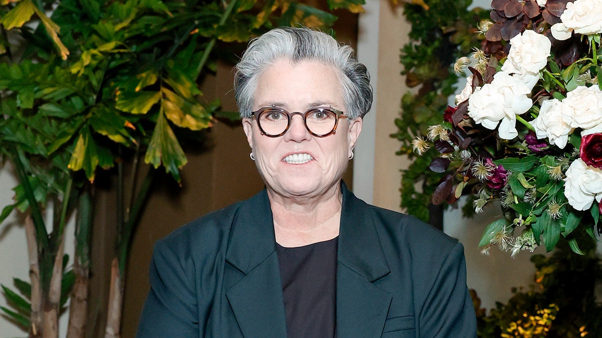 Rosie O'Donnell smiles in front of plants