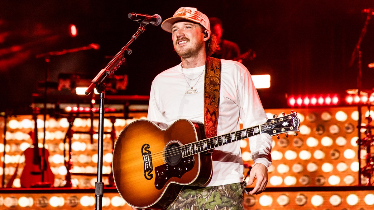 Morgan Wallen performs on stage during his "One Night at a Time" tour in a white long sleeve shirt in September 2024.