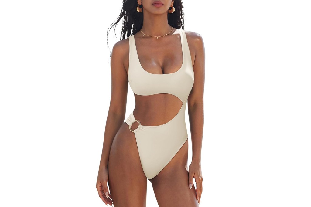 Woman in a beige cut-out swimsuit with a gold O-ring on the hip.