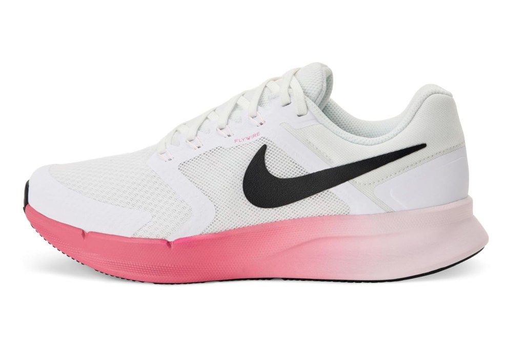White Nike running shoe with black swoosh and pink-to-white ombre sole.