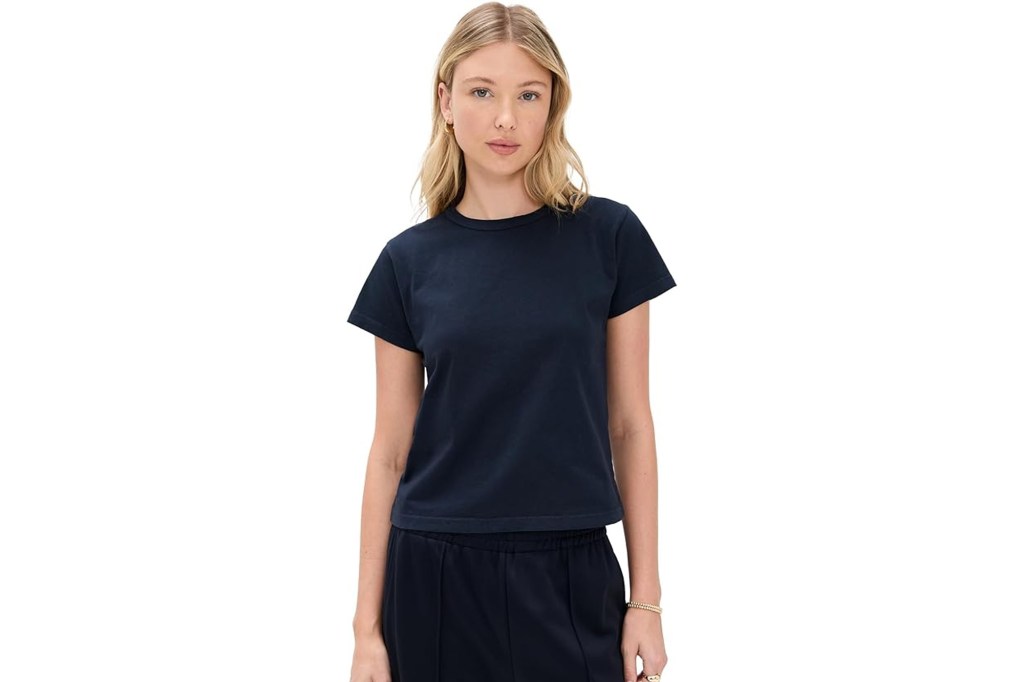 Young woman wearing a dark blue short-sleeved t-shirt and matching dark blue sweatpants.