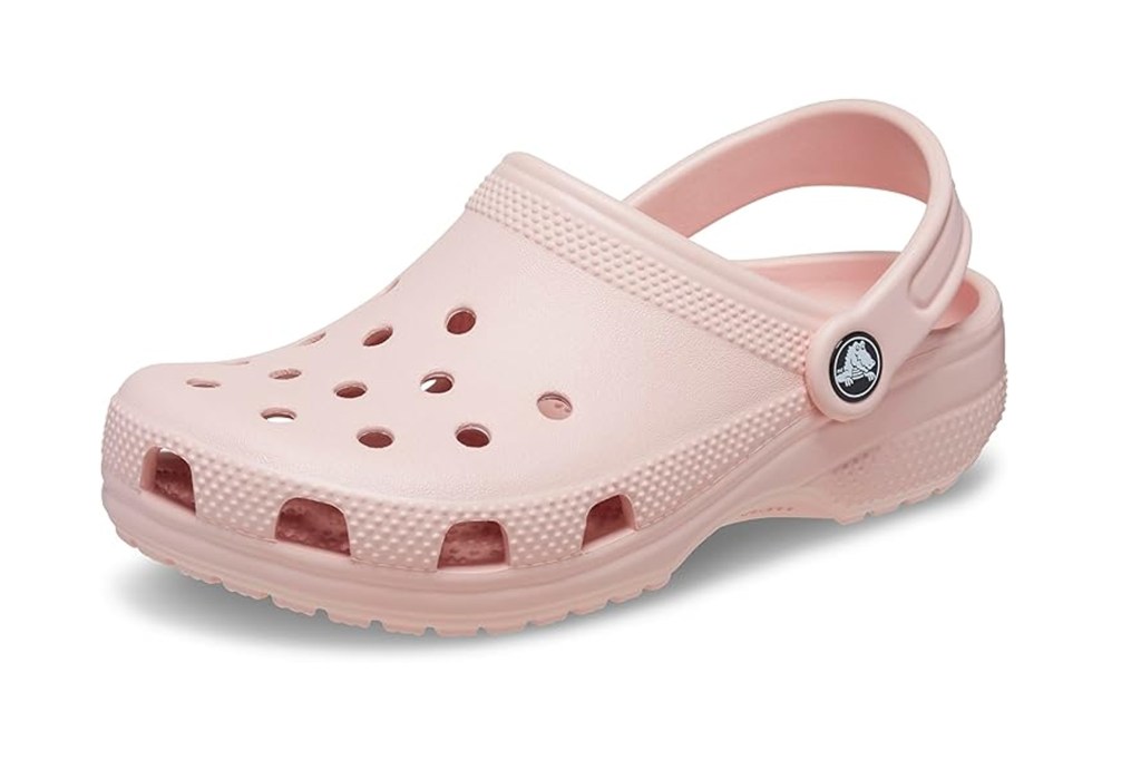 A single pink Croc shoe with ventilation holes and a Crocs logo on the strap button.