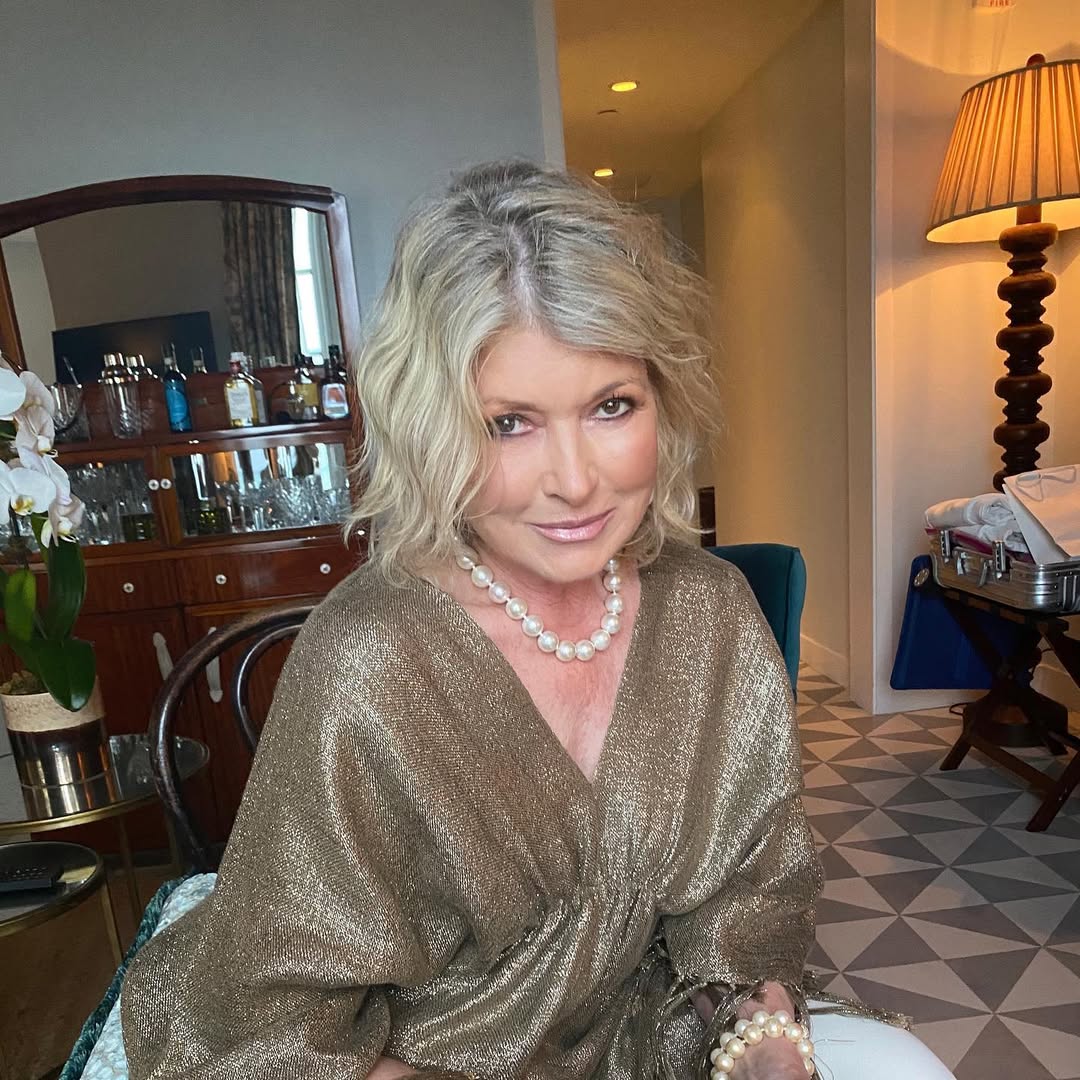 Martha Stewart in a gold dress and pearl necklace.