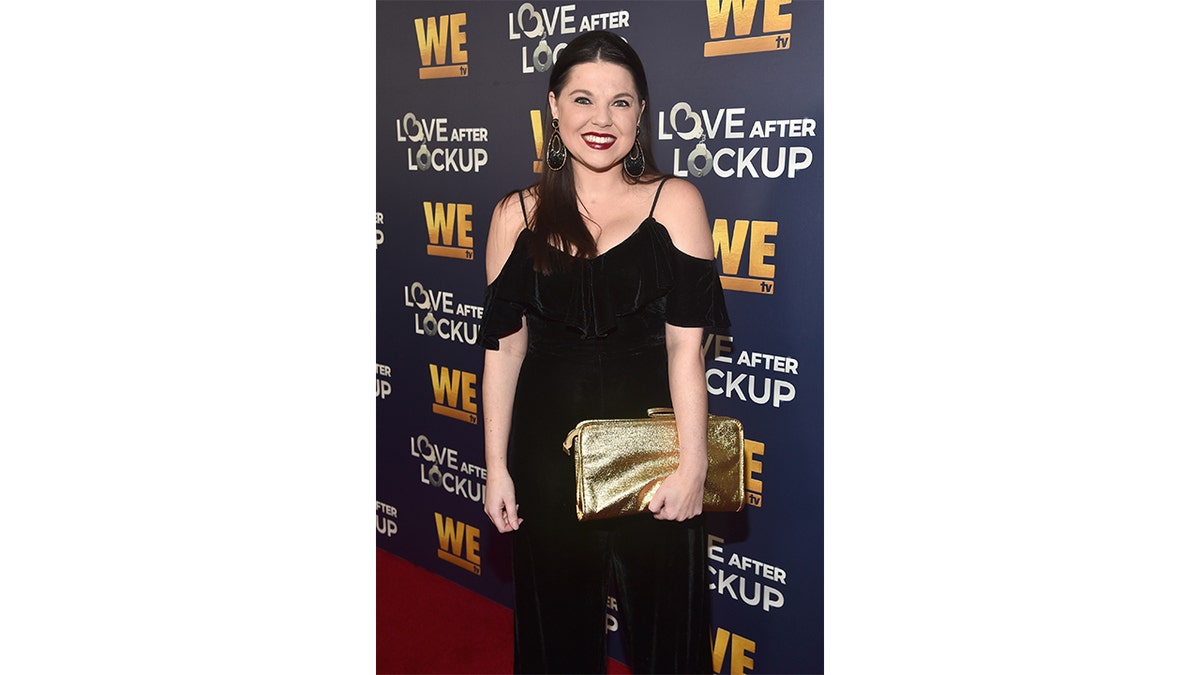 Amy Duggar holds a purse at an event