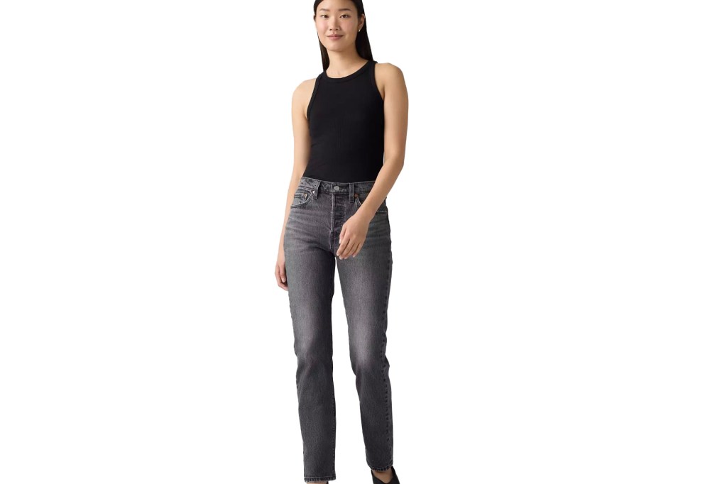 A model wearing black ribbed tank top and dark gray jeans.