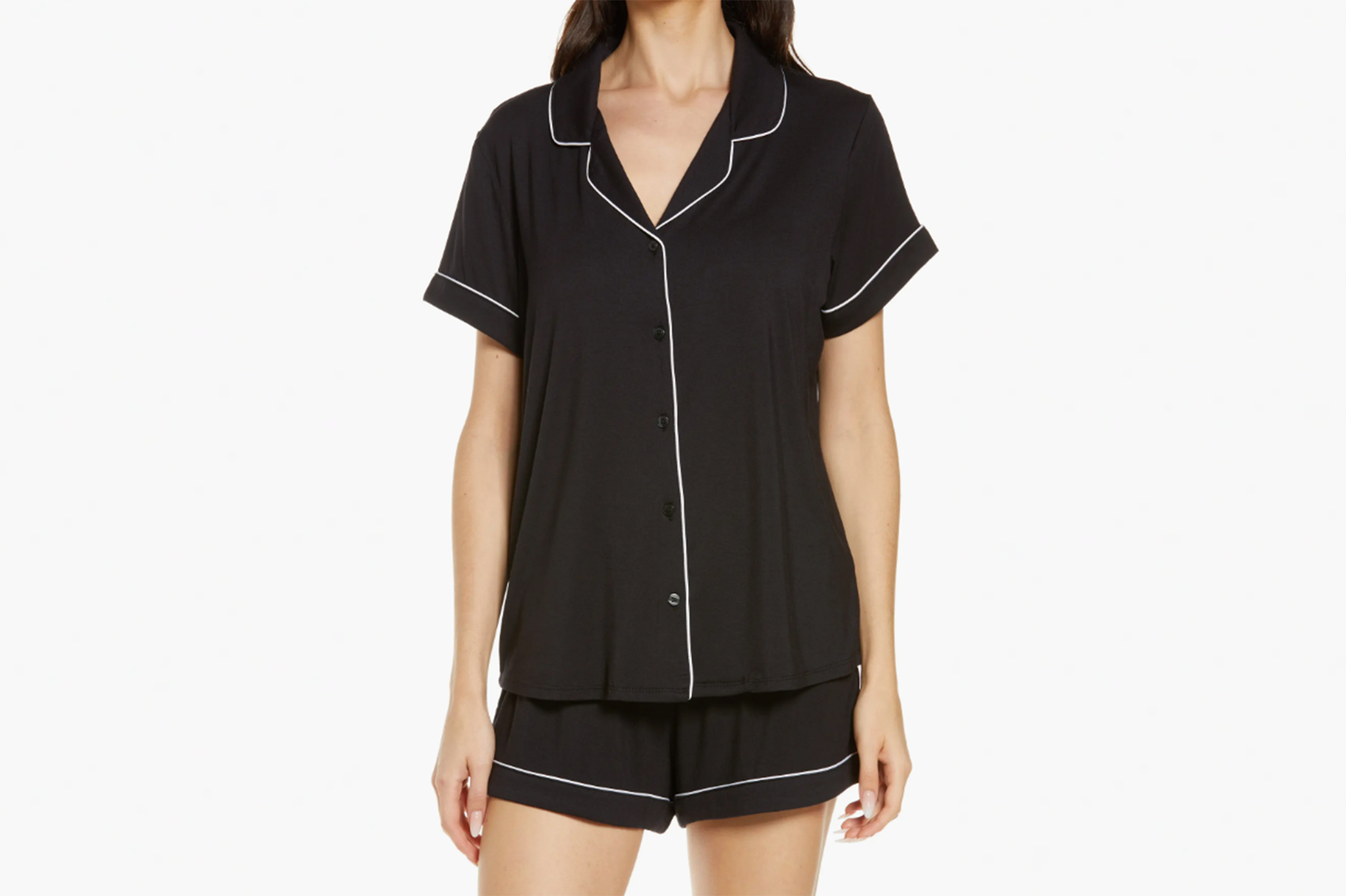 A woman models a black pajama set with white piping.