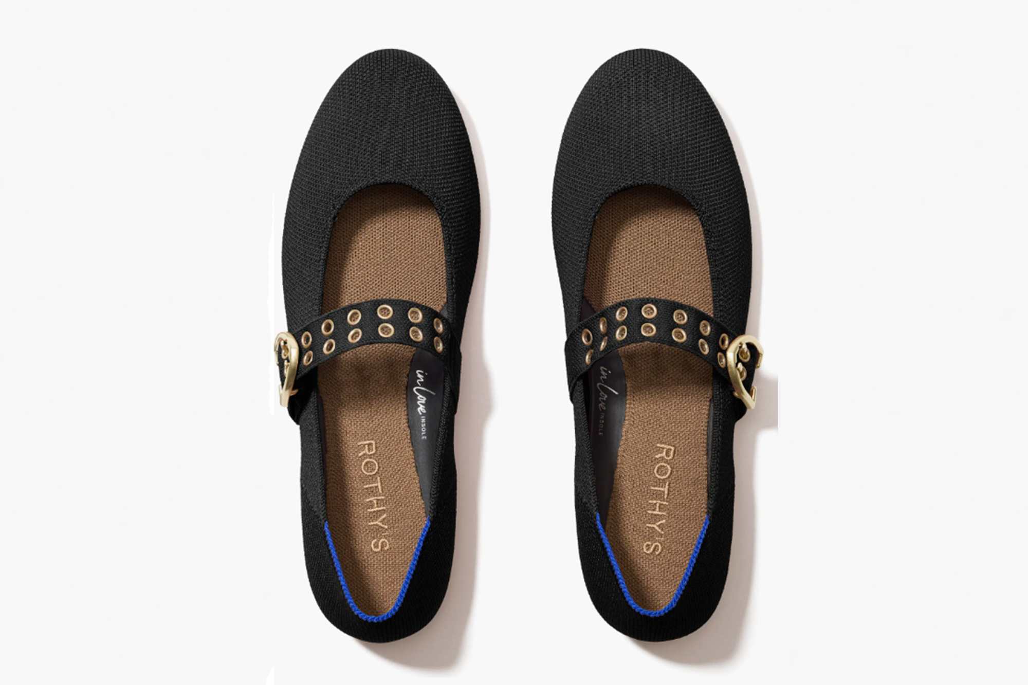 Pair of black Rothy's Mary Jane style flats with a gold buckle and eyelet strap, featuring a blue trim.