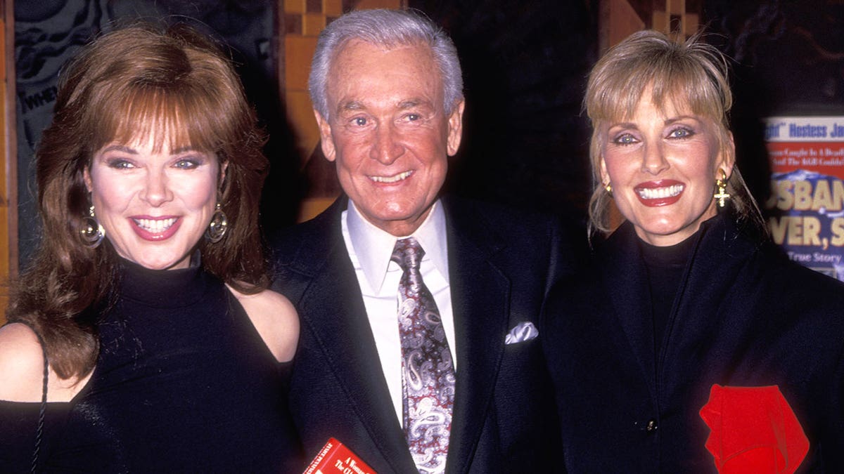Holly Hallstrom, Bob Barker and another "Barker Beauty" smiling together at a book function.