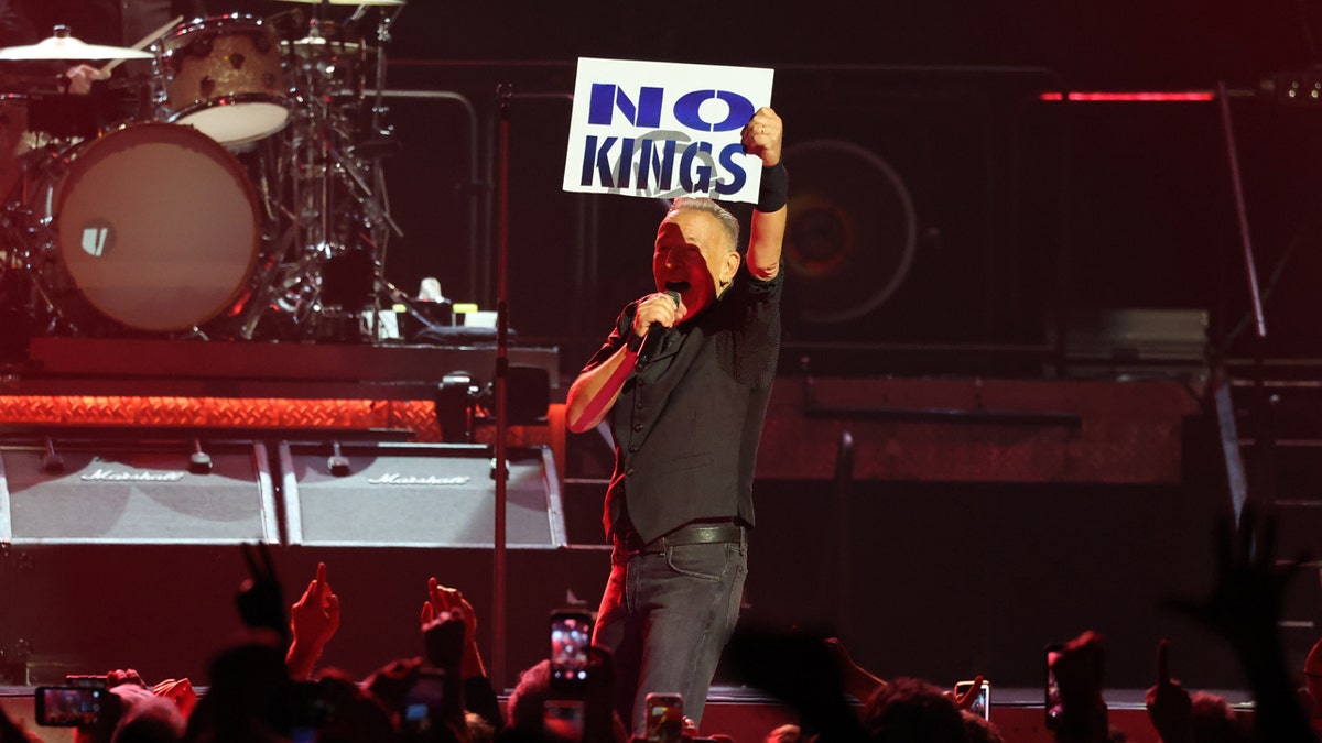 Bruce Springsteen holds a no kings sign.