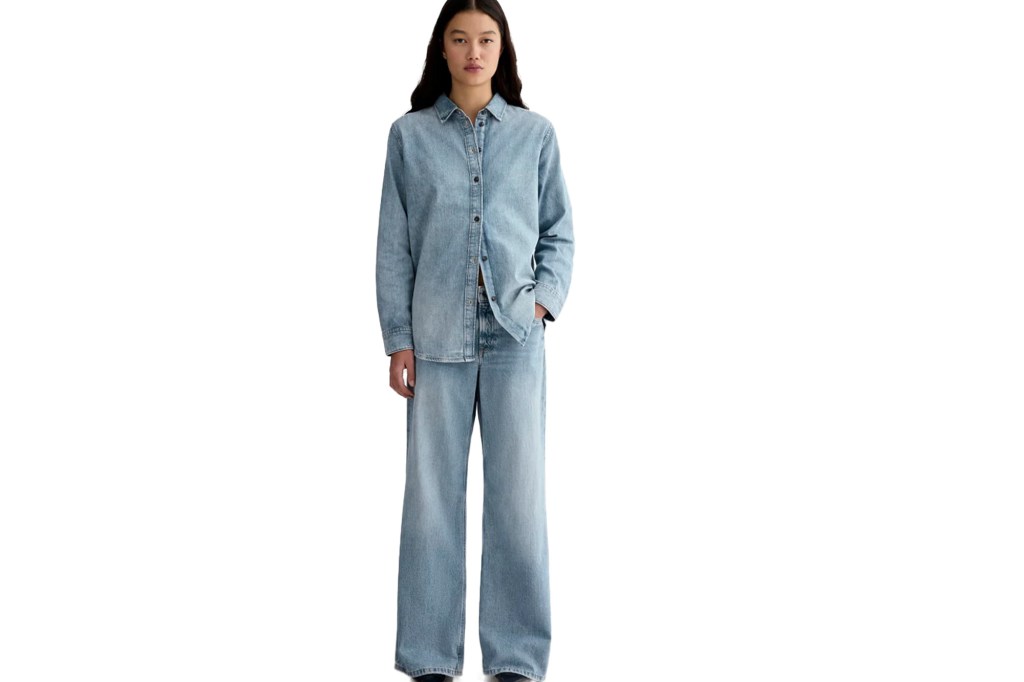 Woman in light-wash denim button-up shirt and matching wide-leg jeans.