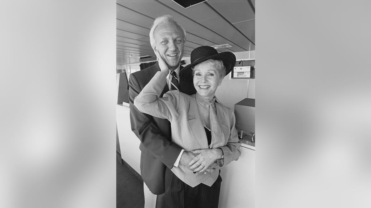Actress Debbie Reynolds and husband Richard Hamlett posing on the bridge of the S.S. Norway cruise ship