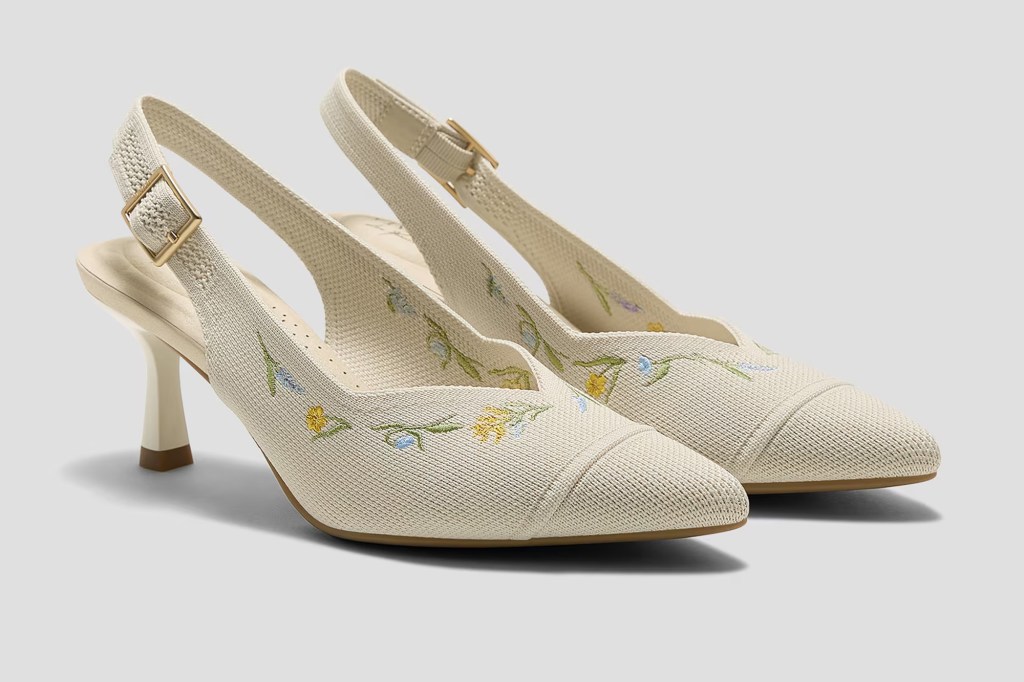 Pair of off-white slingback heels with floral embroidery.