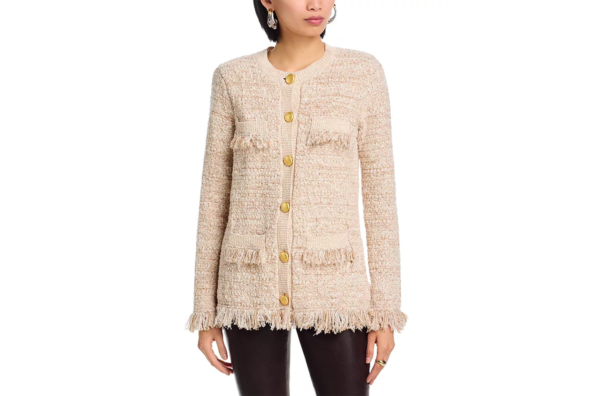 A model wearing a beige tweed cardigan with gold buttons and fringe detailing.