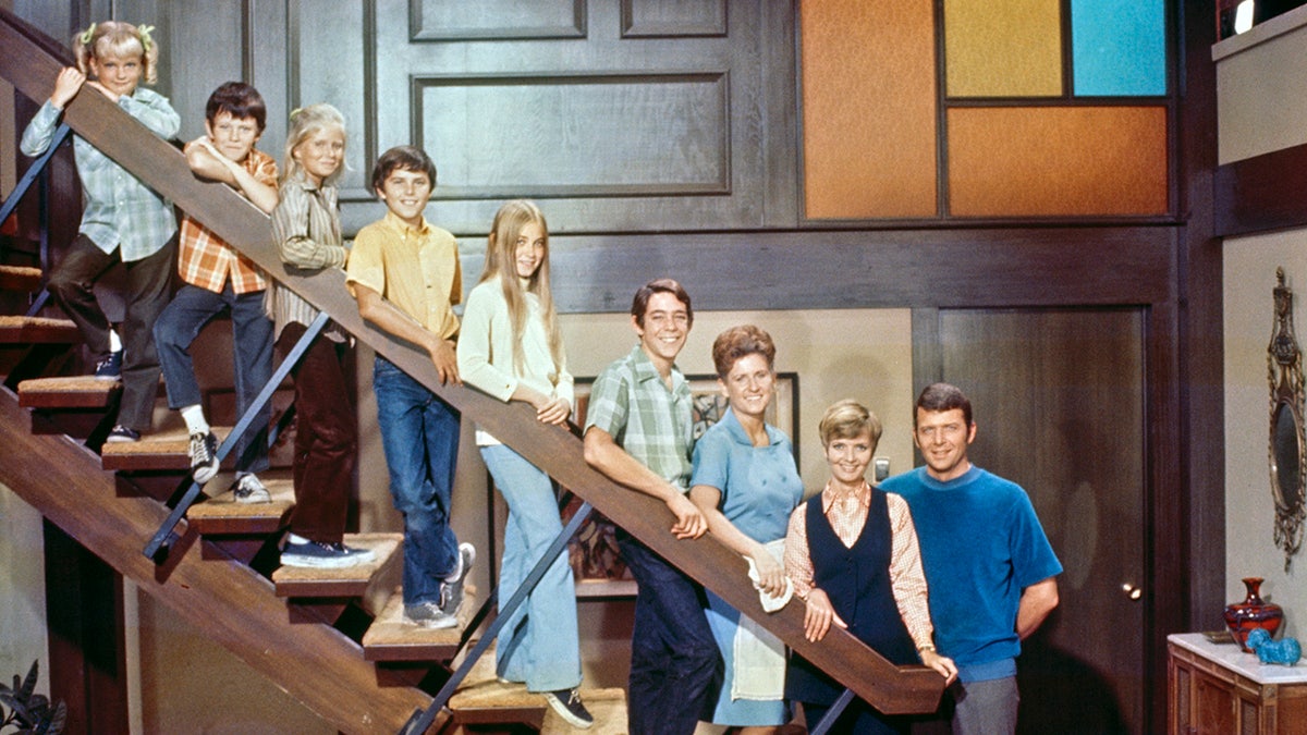 The Brady Bunch cast posing on stairs in a group photo