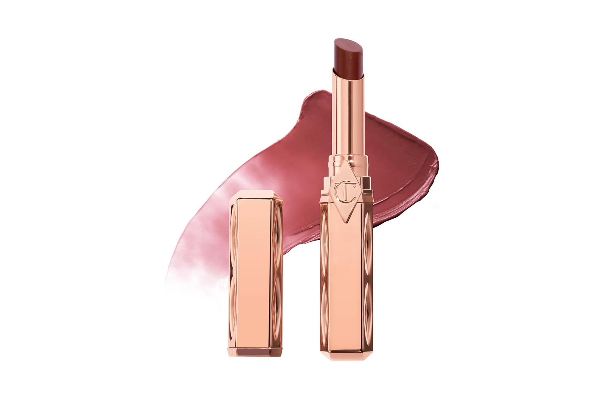 Charlotte Tilbury balm in a rose gold tube next to its cap, with a rosy-brown swatch of the balm behind it.