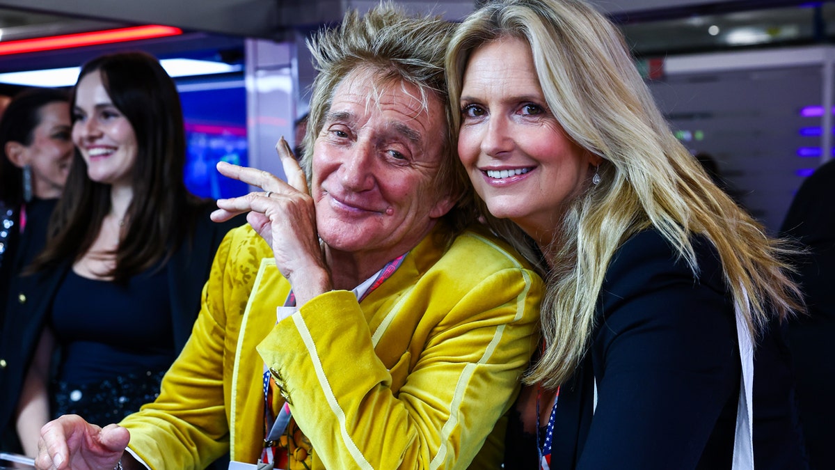 Rod Stewart and Penny Lancaster posing in Red Bull Racing garage