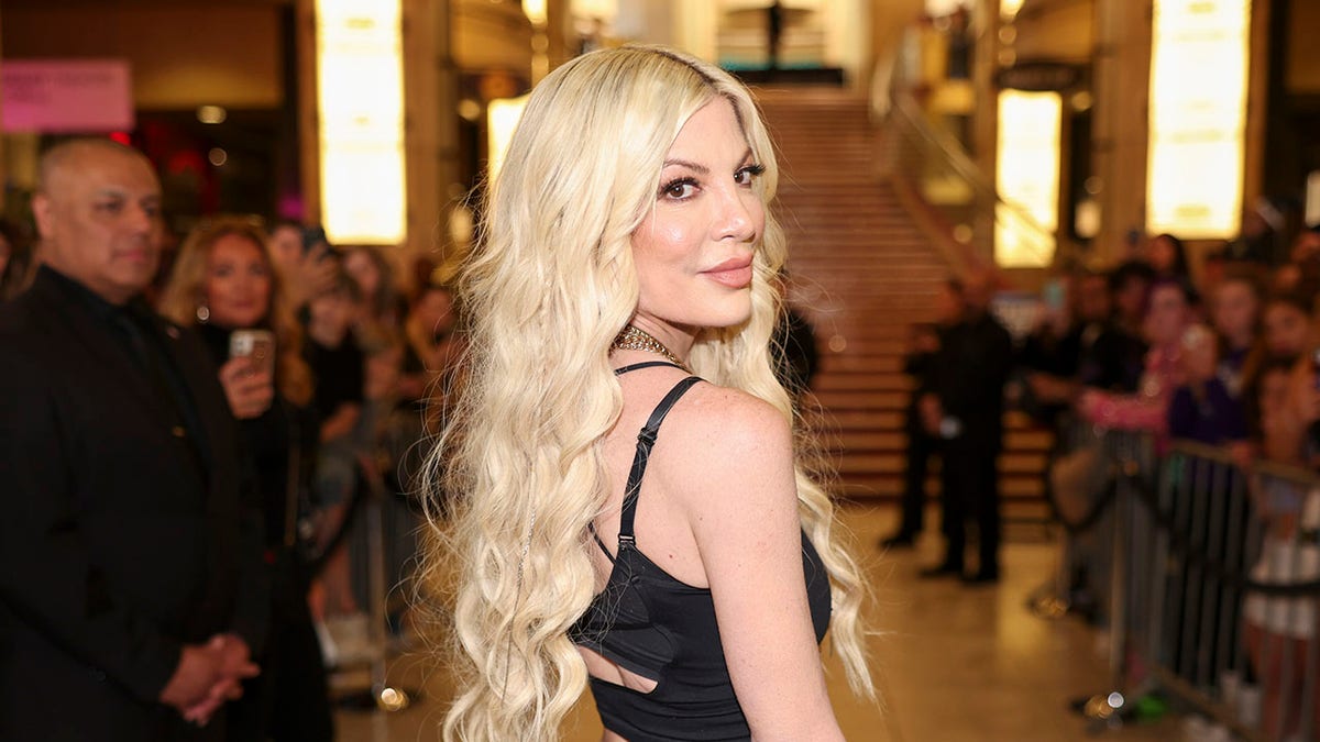 Tori Spelling standing at the 2024 iHeartRadio Music Awards backstage area