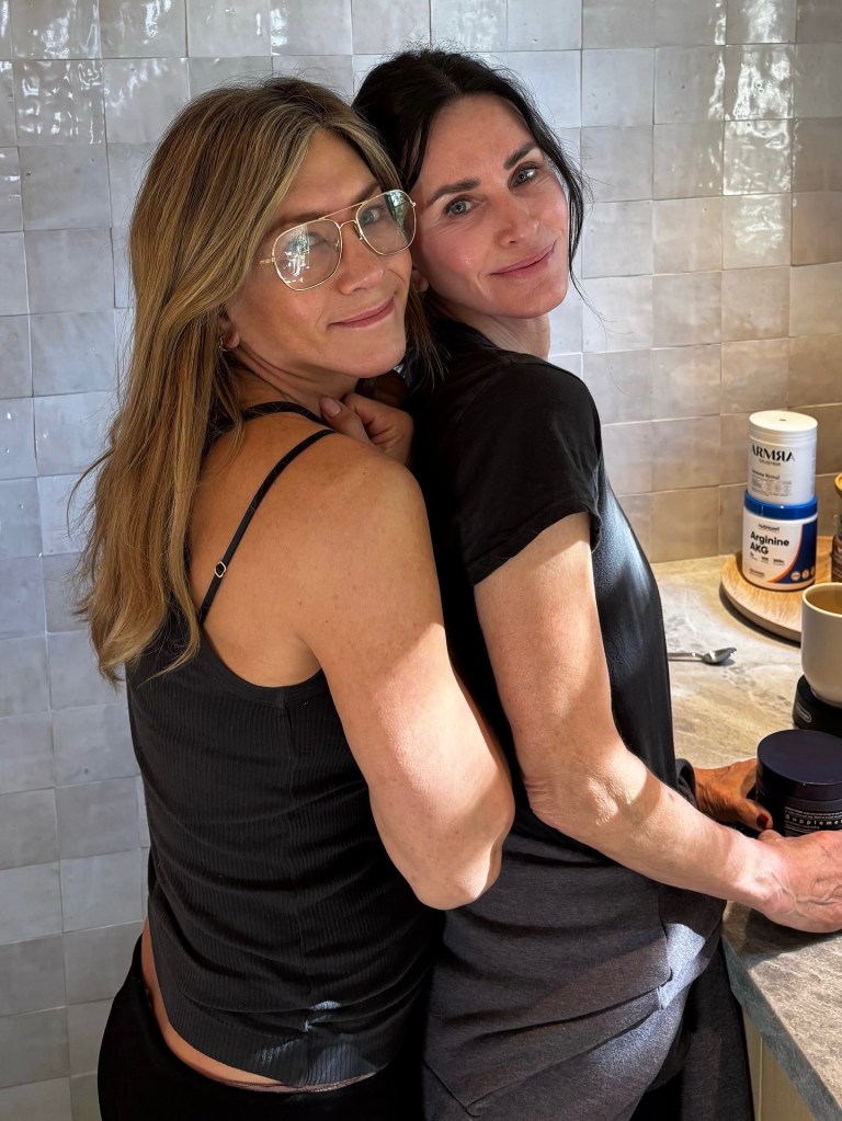 Jennifer Aniston in gold-rimmed glasses with Courteney Cox.