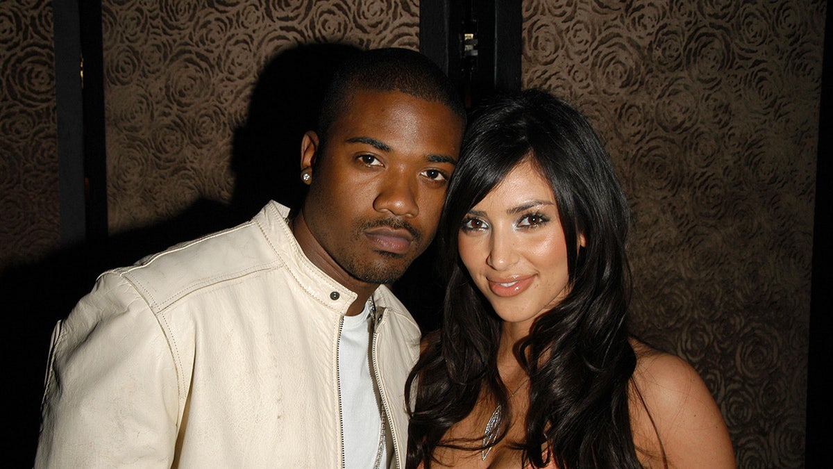 Ray J and Kim Kardashian leaning toward each other at a fashion show