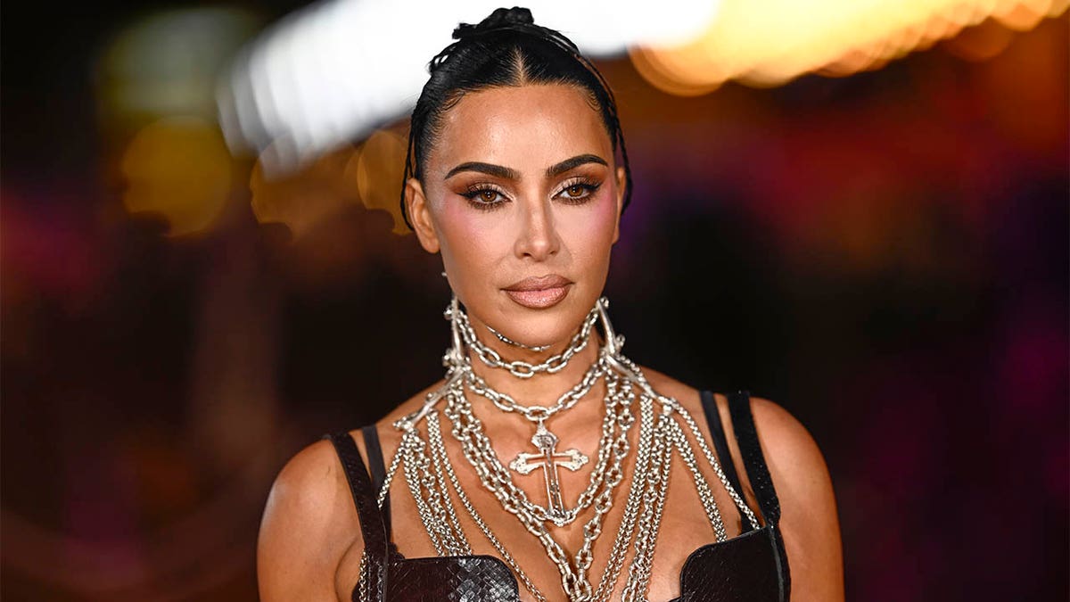 Kim Kardashian wearing a black dress with chains at a London premiere.