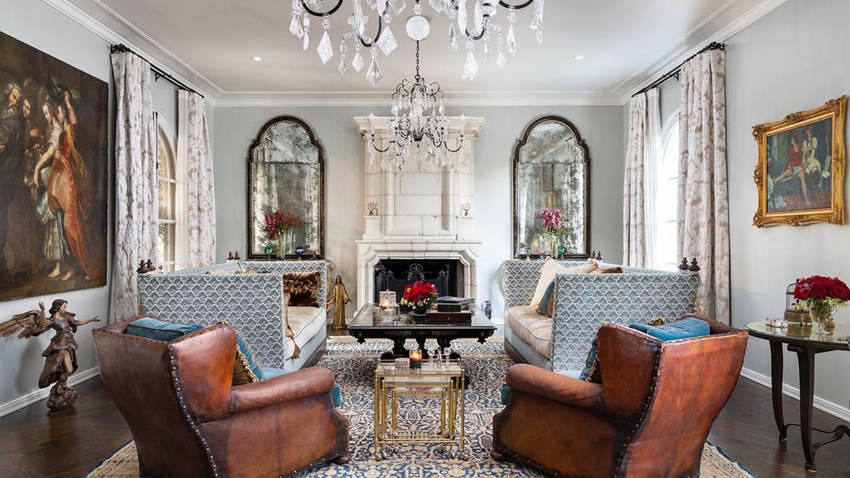 A living room with blue walls, a fireplace and furniture