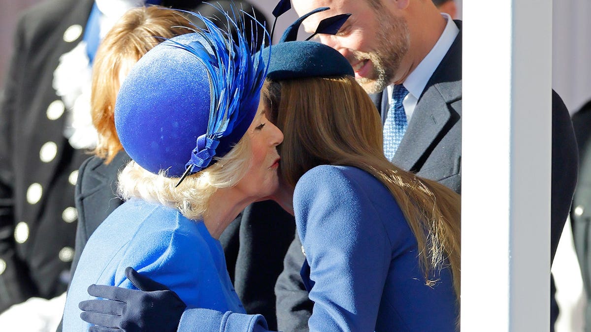 Queen Camilla kissing Catherine Princess of Wales at a formal welcome in Windsor England