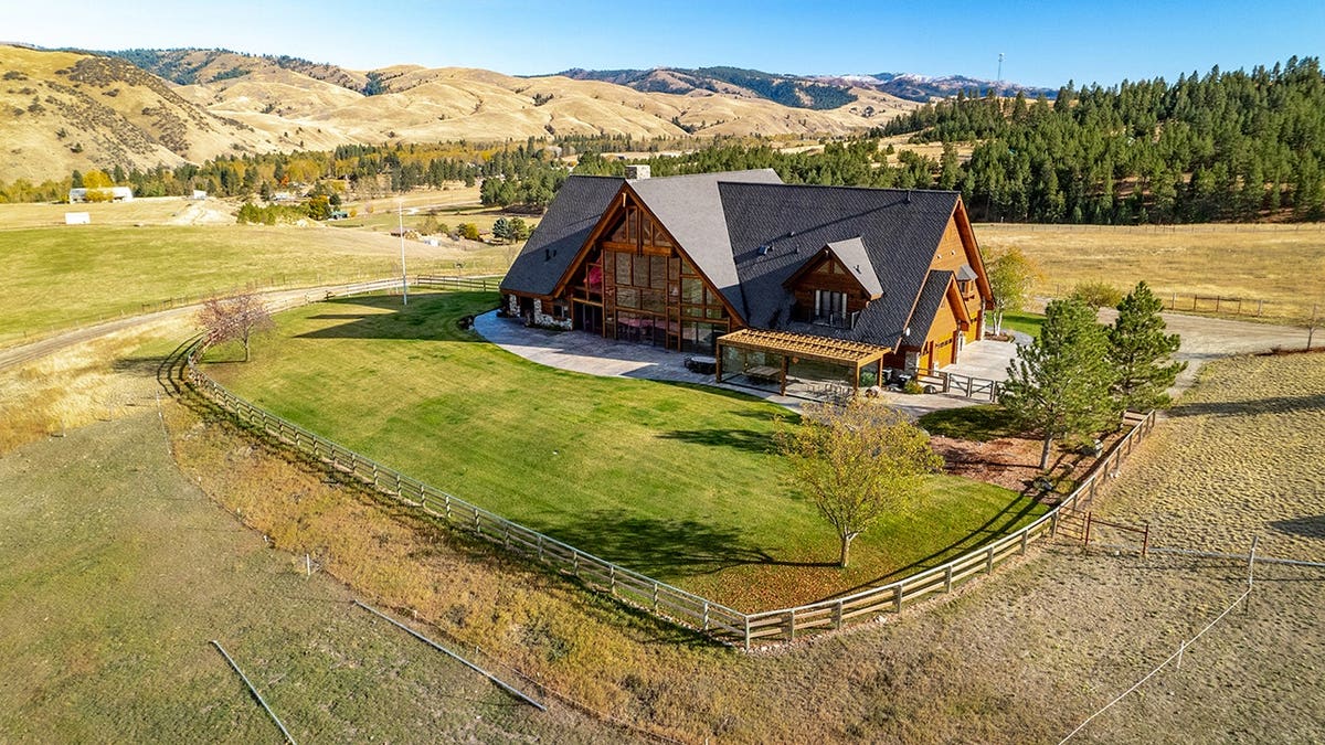 Large luxury ranch home with wood exterior and fenced yard in Montana