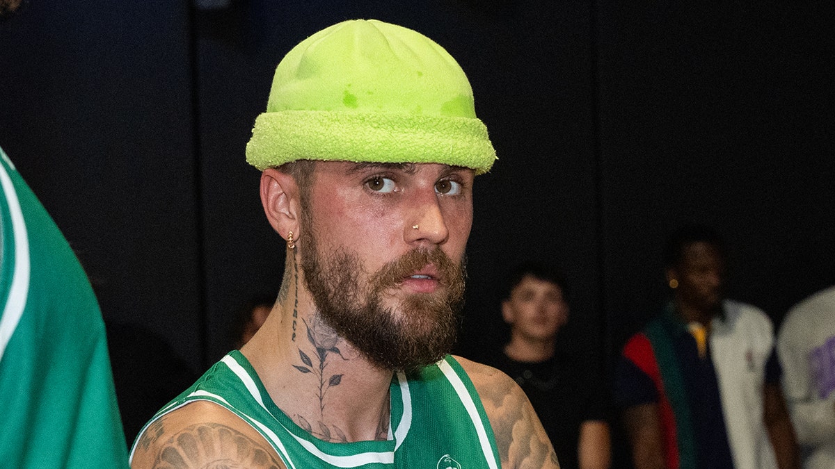 Justin Bieber looking on during a time out at a basketball game.