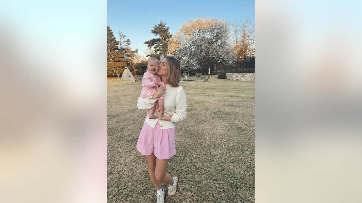 Sadie Robertson holding and kissing daughter Kit