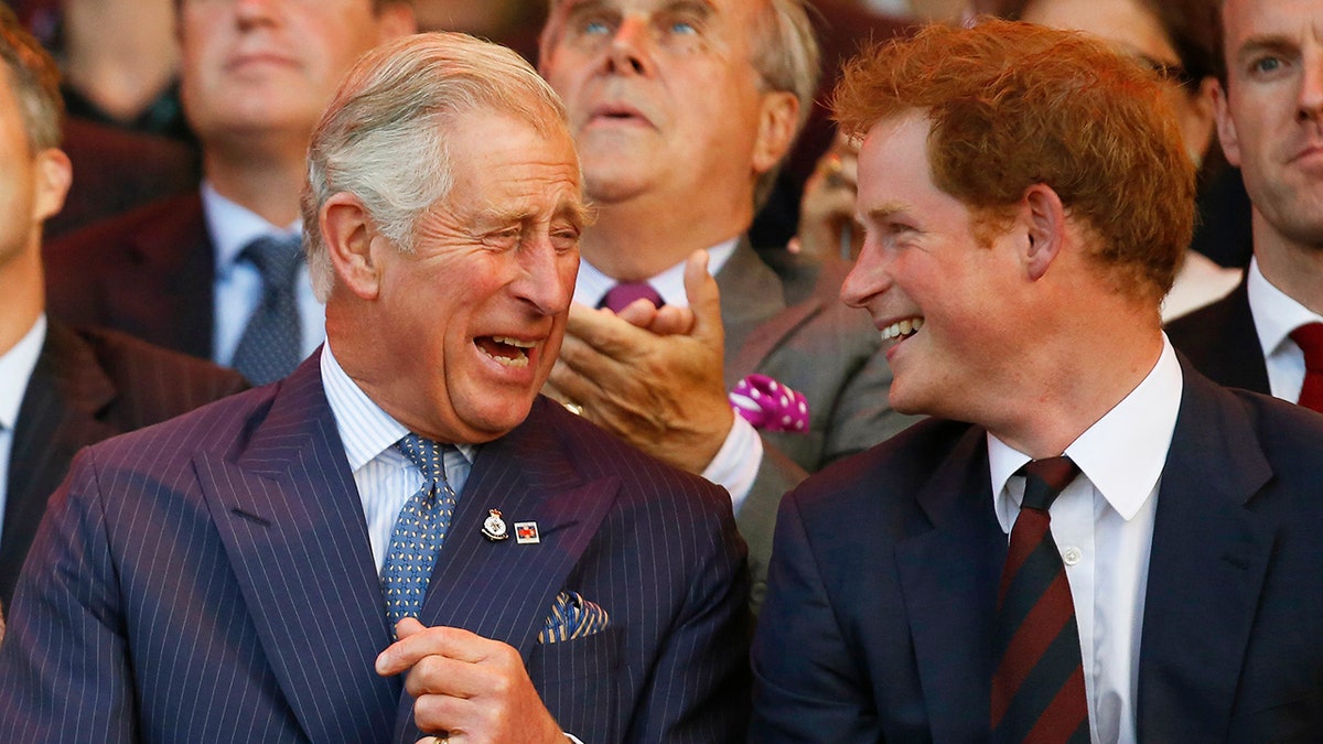 Prince Charles and Prince Harry laughing while seated at the Invictus Games opening ceremony in London