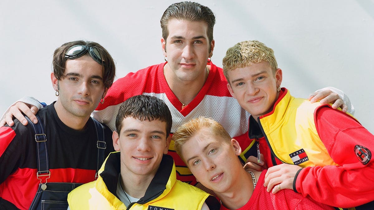 NSYNC band members JC Chasez, Joey Fatone, Chris Kirkpatrick, Lance Bass and Justin Timberlake posing in a studio.