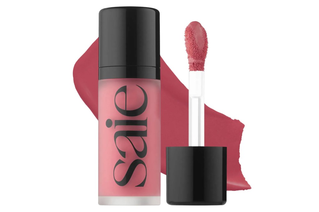 Saie liquid blush in a frosted pink tube with a black cap, next to its applicator dipped in the blush.