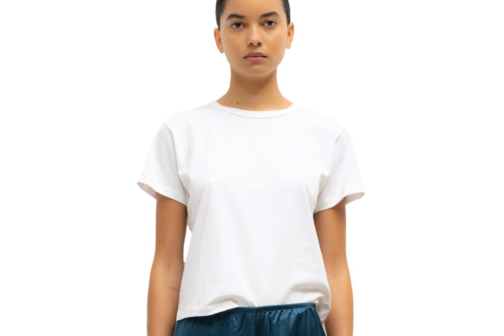 A woman wearing a white t-shirt and blue bottoms.