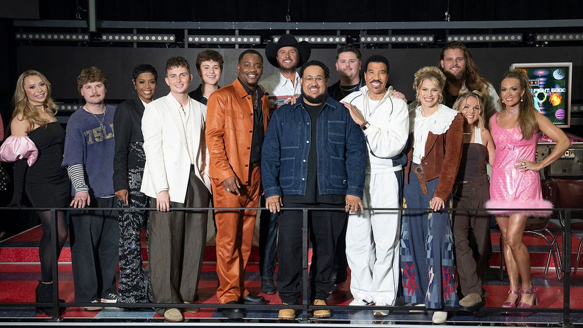 The Top 12 contestants of American Idol performing on stage with judges Luke Bryan, Lionel Richie, and Carrie Underwood