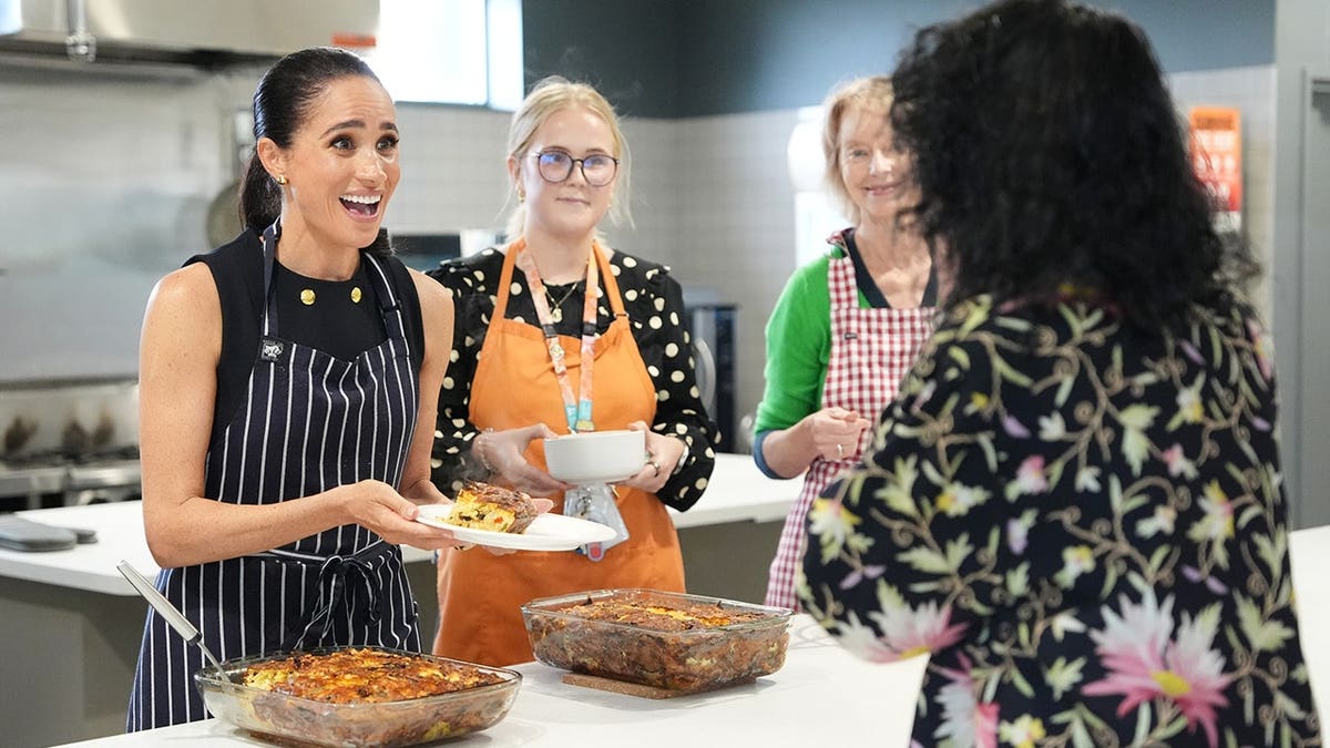 Meghan, Duchess of Sussex, serving lunch to a resident at a women's shelter in Melbourne