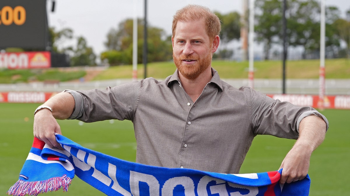 Prince Harry holding a scarf.