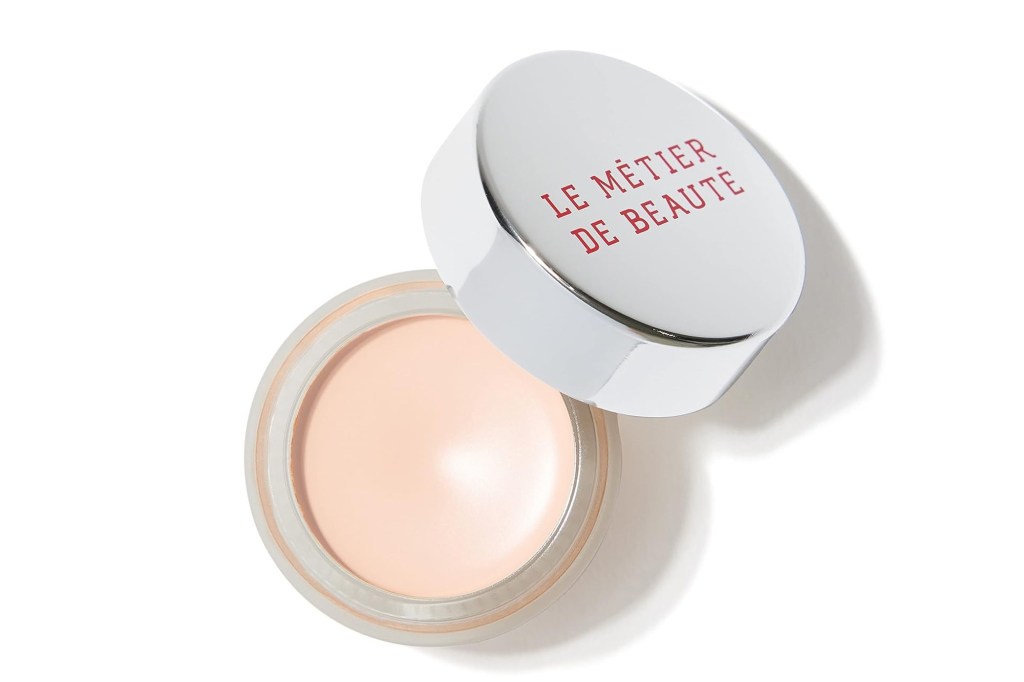 An open pot of light pink Le Metier De Beaute concealer.