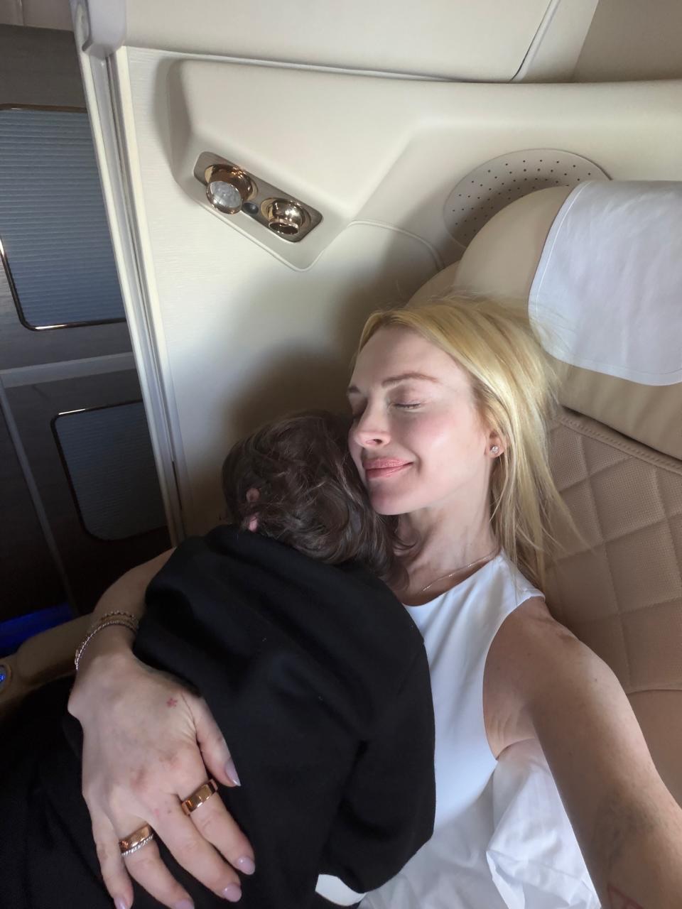 Lindsay Lohan and son cuddle up while catching a flight.