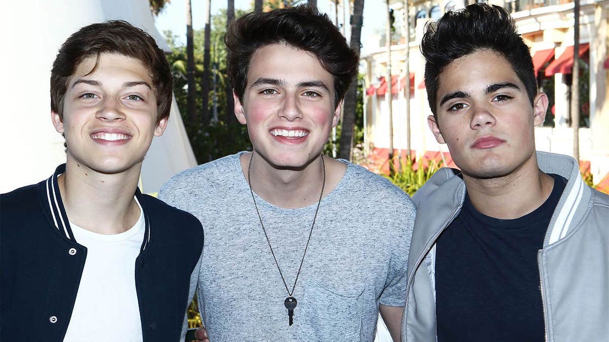 Musicians Ricky Garcia, Emery Kelly and Liam Attridge of Forever in Your Mind posing at an event.