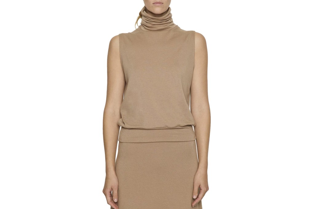 A woman models a sleeveless, camel-colored turtleneck and matching skirt.