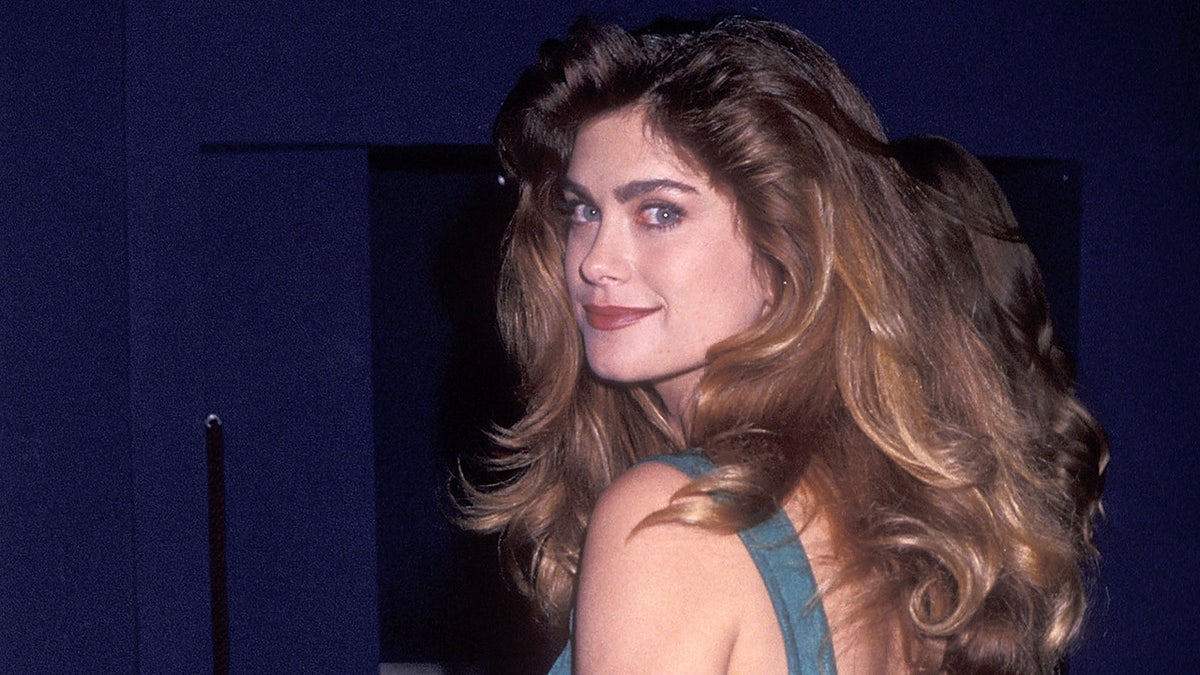 Kathy Ireland smiles in grey dress