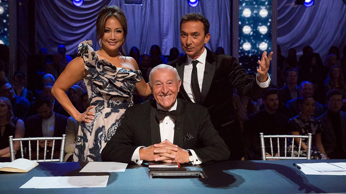 Judges Carrie Ann Inaba Len Goodman and Bruno Tonioli seated at Dancing with the Stars judging desk