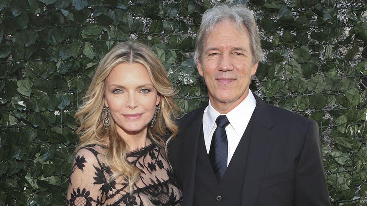 Michelle Pfeiffer and husband David E. Kelley standing together at the Emmy Awards
