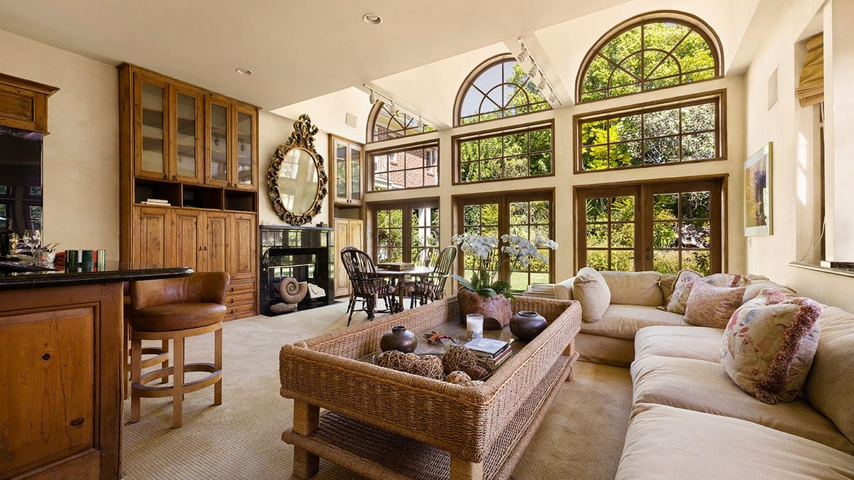 A family room with large windows and a wood-burning fireplace.